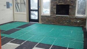 Installing CeraZorb synthetic cork underlayment under the TempZone floor heating system prevents heat loss through the concrete below, allowing more heat to radiate into the room.