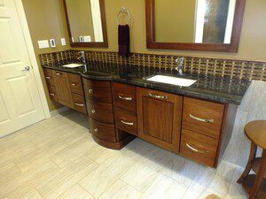 Asian influenced vanity and backsplash complement the luxurious radiant heated porcelain tile flooring in this master bath suite