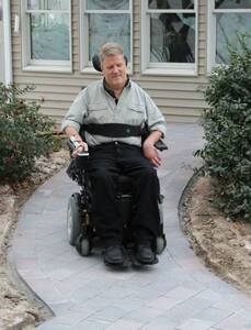 Homeowner Rob Butts tries out his new heated wheelchair ramp, made possible by A Concord Carpenter, WarmlyYours, and a team of contractors volunteering their time and expertise.